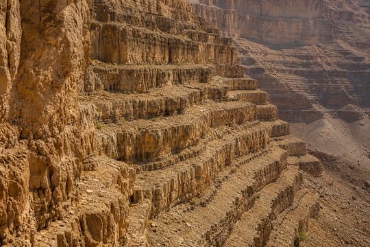 Stepped rock layers in a canyon wall, desert landscape.