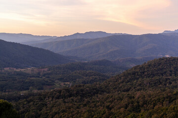 Fototapeta premium Phu Suan Sai National Park in Thailand. Layered mountains with forests in valleys. Misty sunrise with soft light on horizon.