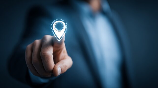 Hand holding a blue location pin marker on a blurred blue background