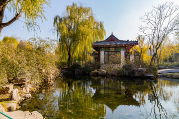 Naklejka premium Traditional pavilion by pond in Wulongtan Park, Jinan, Shandong, China