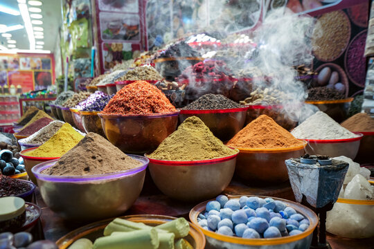 Dubai, United Arab Emirates - 21 April 2023: View of colorful spice mounds in bowls at the traditional spice souk, with aromatic powders and herbs displayed in a market stall.