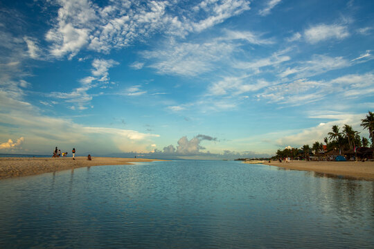 Cebu, Central Visayas, Philippines - 21 June 2026: View of Bantayan Island beach with calm water, white sand, palm trees, and people relaxing under a blue sky with clouds.