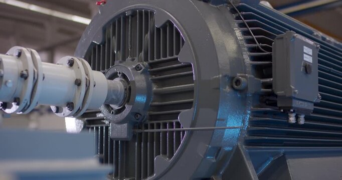 Side profile of a large industrial electric motor with cooling fins and a coupling shaft