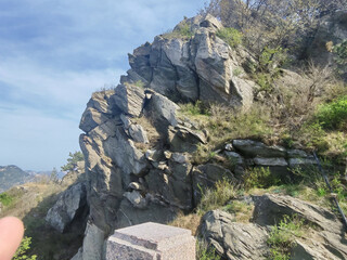 Rocky Cliff Landscape with Sparse Vegetation and Blue Sky © TuongDuc
