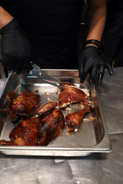 chef troceando pollo reci&eacute;n asado con una tijera de cocina