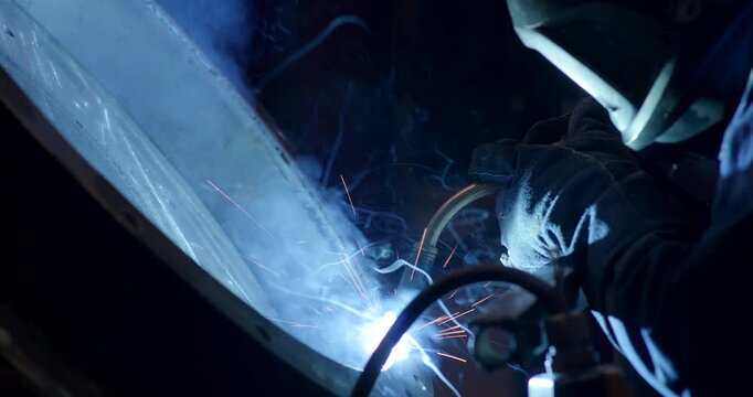 Close up view of intense electric arc welding on metal parts in an industrial workshop