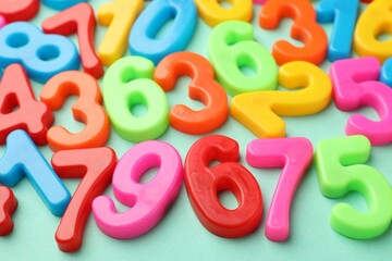 Fototapeta premium Many colorful numbers on turquoise background, closeup