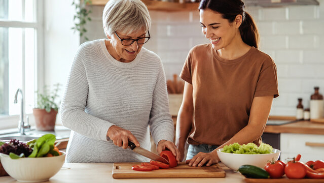 Caregiver And Senior Preparing Healthy Meal
