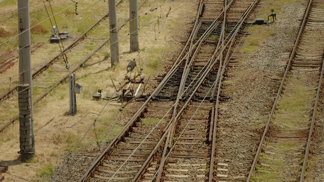 The image shows electric wires and current dividers positioned over railway tracks in an industrial area. The setup is important for power distribution along the railway.