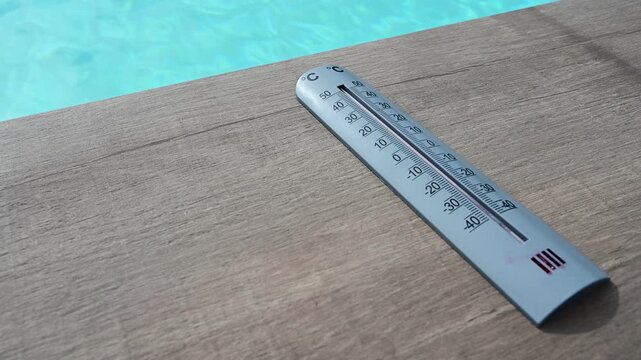 Thermometer and swimming pool in France during a heatwave and the hottest day recorded in the country.