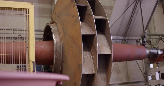 Close-up of a large metallic industrial rotor blade assembly attached to a horizontal shaft
