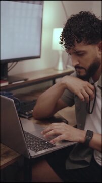 Focused hispanic professional typing on laptop at night