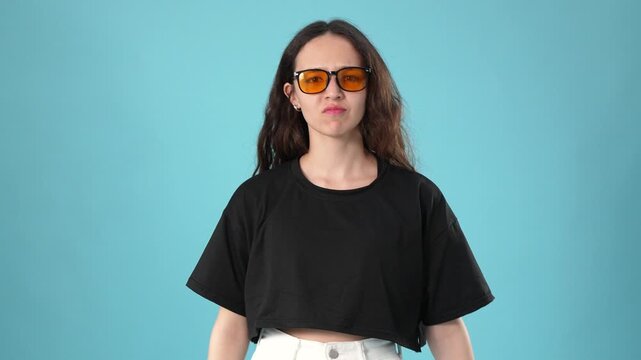 Confused young woman in sunglasses shrugging shoulders in uncertainty