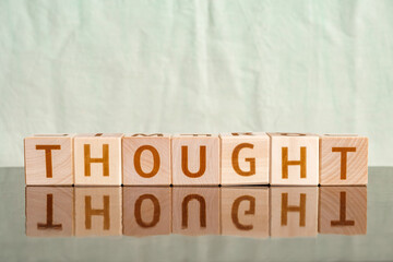 Naklejka premium thought, motivational word made of letters on wooden cubes