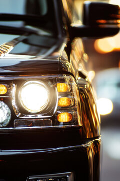 Close-up of car headlights on a city street at night vertical frame