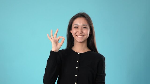 Pretty woman gesturing and making positive hand signs studio