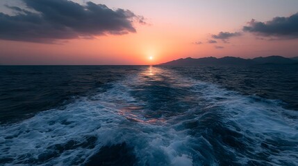 Obraz premium A vibrant azure sunset illuminates the distant horizon over the ocean featuring swirling foam and dramatic light