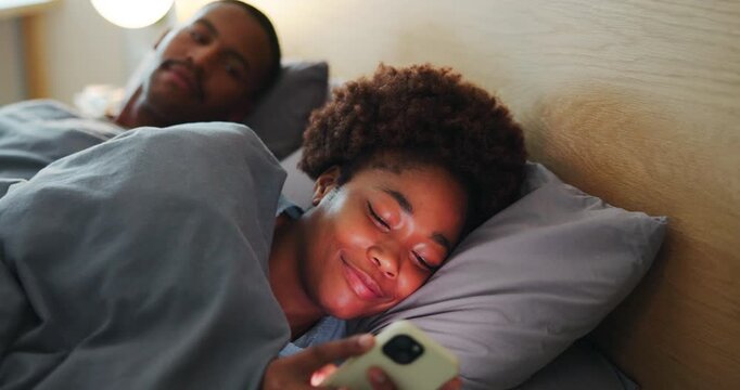 Woman, phone and couple in bed with cheating, secret text message or unfaithful in relationship at night. Wife, African man or tech in home bedroom with suspicion, online dating or late communication