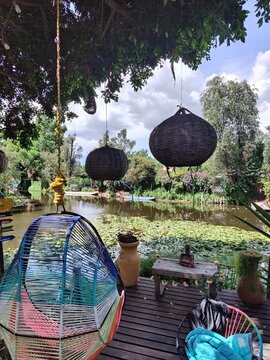 Bohemian Lakeside Terrace with Woven Hanging Lanterns Overlooking Xochimilco Canal, Mexico City