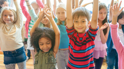 Fototapeta premium Diverse children raising hands joyfully