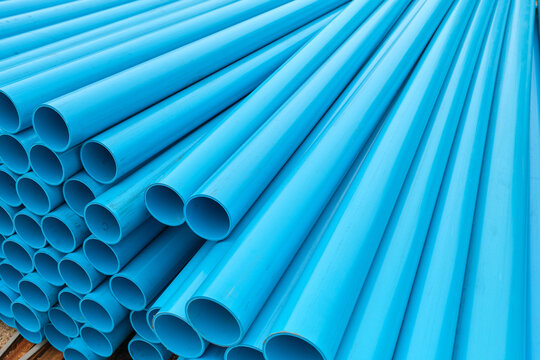 Perspective View of Stacked Pipes Extending into Distance. Rows of stacked pipes recede into the distance, creating depth and leading lines