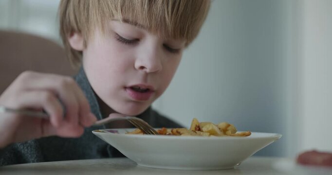 Kid Boy Eat Fried Potato. Eating Breakfast Lunch in Kitchen. 4K 10-bit
