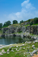 Fototapeta premium Sharp, white, marble-like rocky cliffs of Tarpania Lake, Marble Lake, Blue Dam, Patal Dam or Durga Bera,a scenic lake in the Ajodhya Hills of Purulia, West Bengal, India. Lake has Deep blue water.