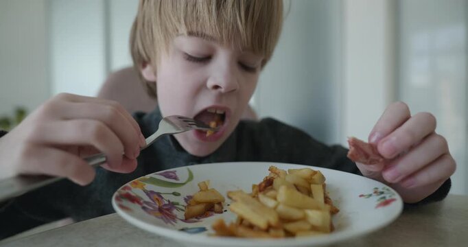 Kid Boy Eat Fried Potato. Eating Breakfast Lunch in Kitchen. 4K 10-bit