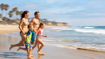 Fototapeta premium Family running on beach, smiling and playing in shallow water
