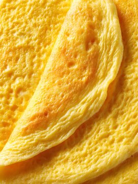 Fluffy American-style omelette with a soft golden exterior and tender folded layers, isolated on a white background.