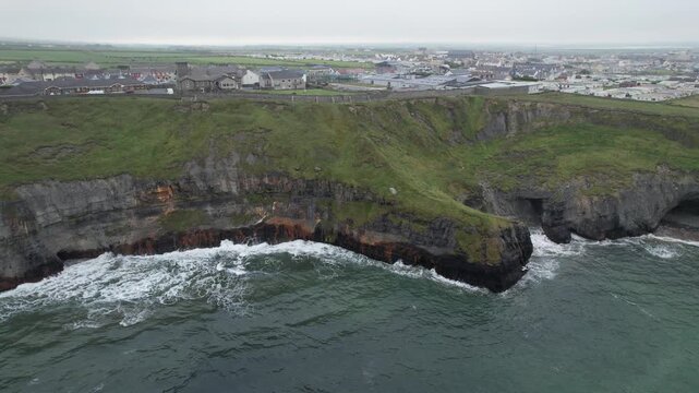 Drone Aerial footage 4k ultra high definition capturing the dramatic cliffs of Ballybunion, ireland, with powerful atlantic waves crashing against the rocky coastline