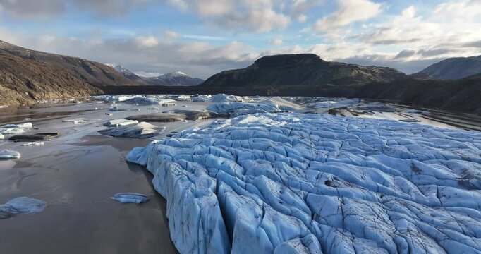 4K Drone aerial view flying over a majestic glacier with ice crevasses in Iceland