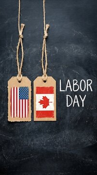Usa and canada flags on cardboard tags against a black chalkboard