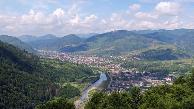 Handheld POV shot descending on a chairlift with a view of a mountain valley and river