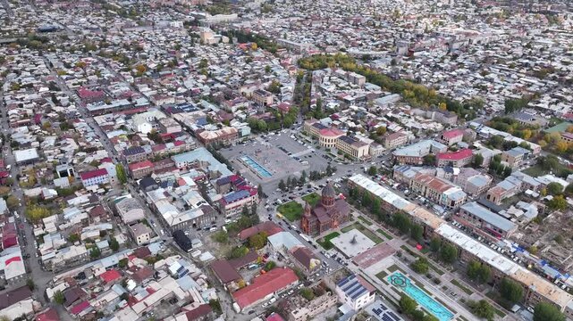 Aerial drone shot of the beautiful city of Gyumri in Armenia, showcasing its historic architecture, busy city squares, streets, and the famous landmark Holy Saviour's Church during autumn.

