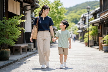 Fototapeta premium 観光地の通りを手をつないで歩く親子