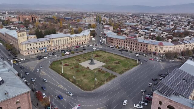 Aerial drone shot of the beautiful city of Gyumri in Armenia, showcasing its historic architecture, busy city squares, streets, and the famous landmark Holy Saviour's Church during autumn.

