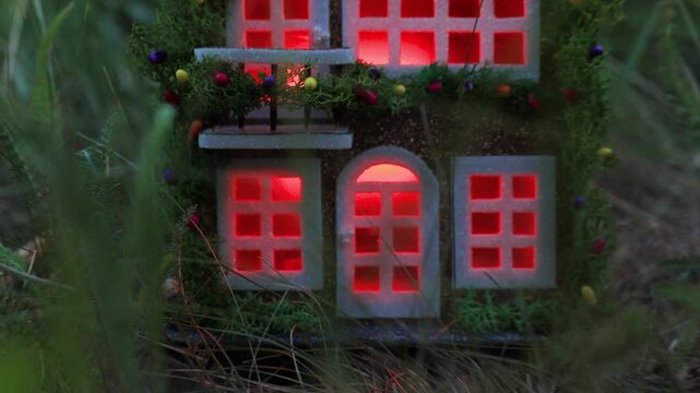 Among the dense greenery there is a fairytale decorated house with color-changing light in the windows