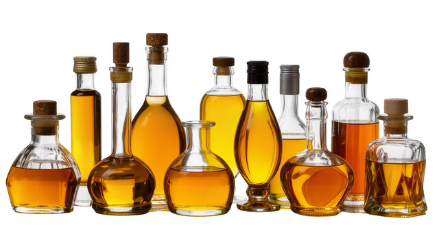 Isolated collection of diverse elegant glass bottles filled with golden amber liquid in a row