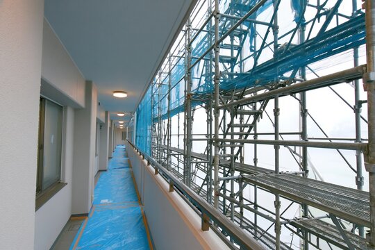 マンション外壁工事中に組まれた足場と青い養生ネット