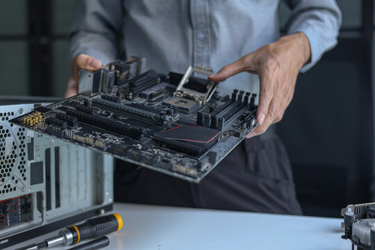 Computer engineer repairing computer motherboard and hardware components.