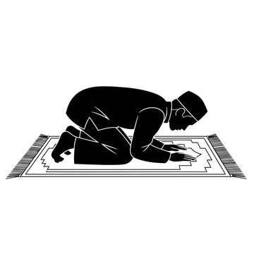 Silhouette of a muslim man performing sujud or prostration during prayer on a prayer rug