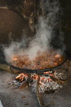 Vertical traditional Valencian paella steaming in wood fired oven