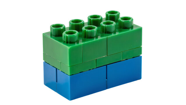 Isolated two plastic toy building blocks stacked on each other, green and blue colors