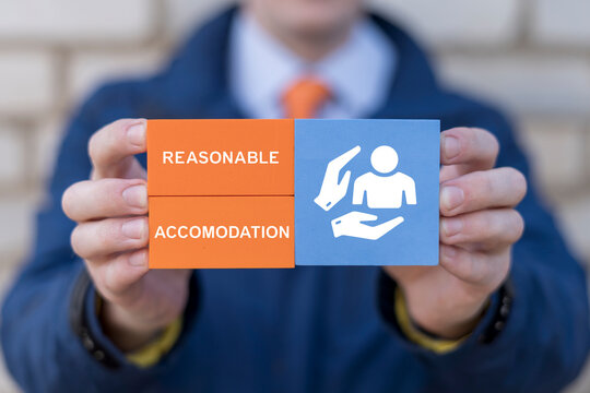 Сoncept of reasonable accommodation. Businessman holding blocks with icon of person and hands sees the text REASONABLE ACCOMMODATION.
