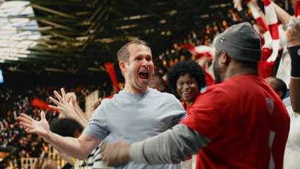 Excited diverse supporters jumping after winning live bet result, stadium crowd with adrenaline enjoying team victory. © DC Studio