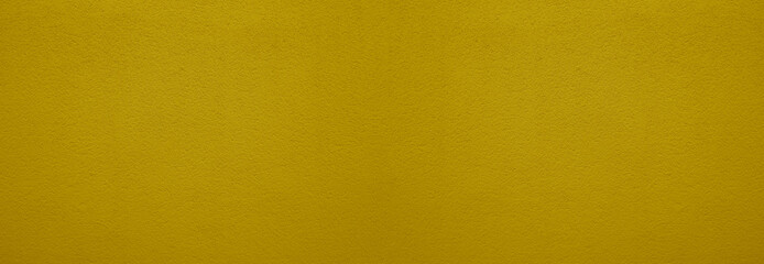 Fototapeta premium Textured background. Decorative plaster wall, external of facade. Texture of yellow golden gold stucco plaster wall of clay house structure background. clay cement texture pattern