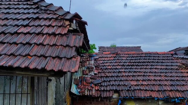 rain falling on a roof of the house in the village in maharashtra in india.
