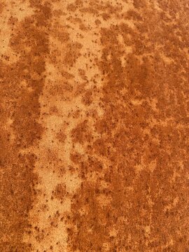 Full frame texture of heavily rusted orange metal sheet or corten steel