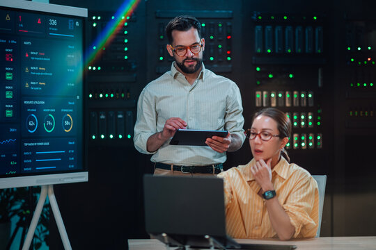 It team collaborating in a server room, managing network infrastructure, monitoring system performance, and ensuring data security